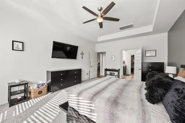 a spacious bedroom with a bed and a flat screen tv