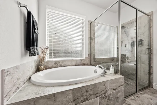 a white bath tub sitting in a bathroom next to a window