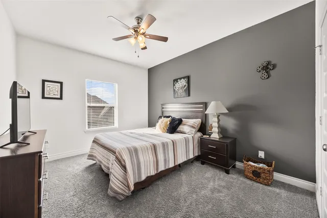 a spacious bedroom with a bed and a chandelier