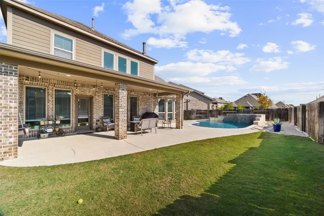 a view of a house with swimming pool and a yard