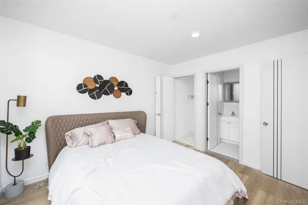 a bedroom with a bed and a potted plant