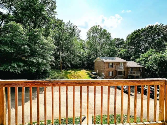 a view of balcony with wooden floor and fence