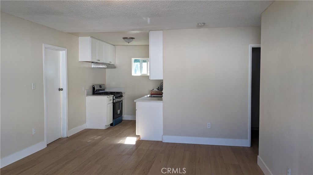 a view of a kitchen with a sink and wooden floor