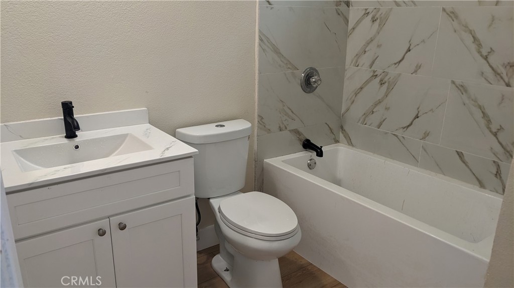 25401 Spring Street Perris, CA 92570 - Photo 3 of 3 a bathroom with a sink a toilet and shower