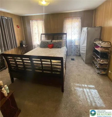 a bed sitting in a bedroom and a flat screen tv