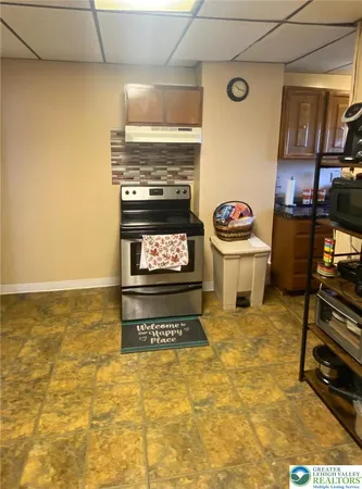 a kitchen with stainless steel appliances a stove a refrigerator a sink a dining table and chairs