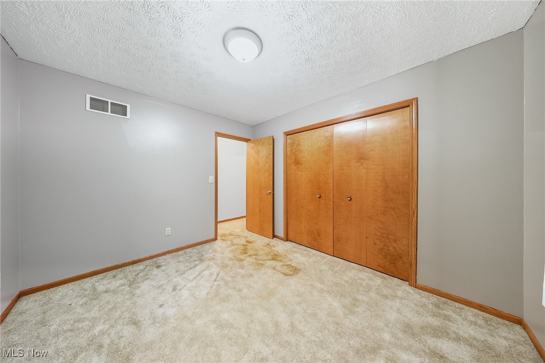 425 Overlook Drive Rittman, OH 44270 - Photo 7 of 44 Unfurnished bedroom featuring a textured ceiling, carpet, and a closet