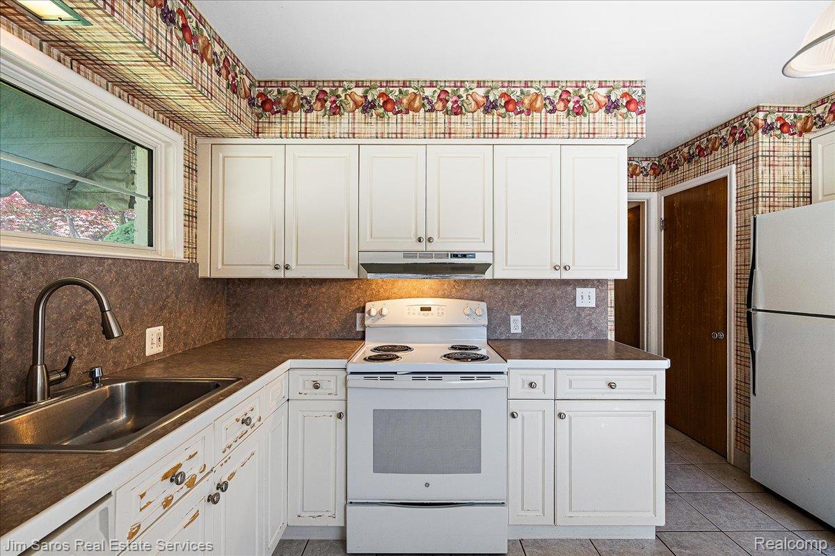 1010 Nottingham Road Grosse Pointe, MI 48230 - Photo 9 of 30 Kitchen featuring white cabinetry, a stainless steel sink with a gooseneck faucet, and a white range