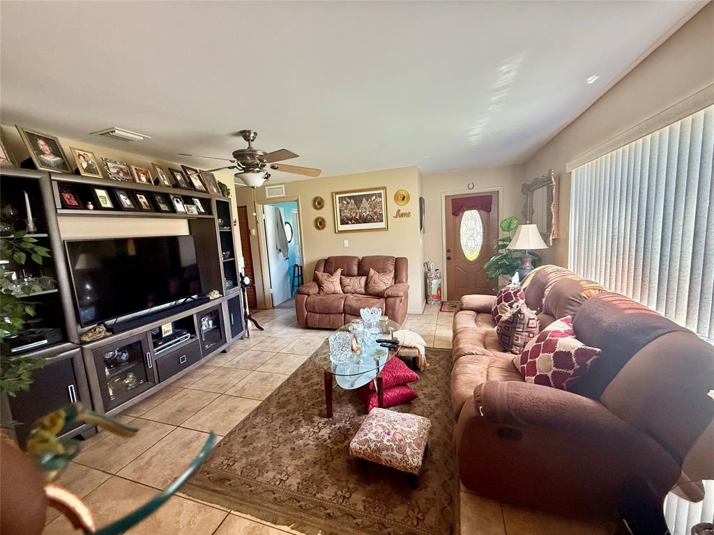 10262 Southwest 179th Street Miami, FL 33157 - Photo 3 of 26 a living room with furniture and a flat screen tv