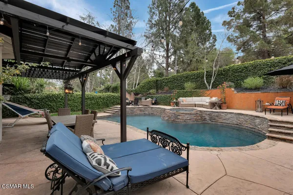 a view of a house with pool and sitting area