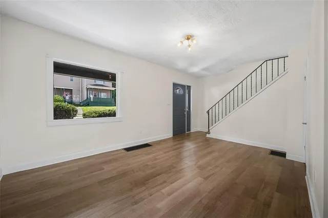 a view of staircase with wooden floor and white walls