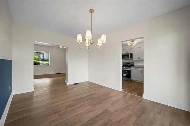a kitchen with cabinets stainless steel appliances and wooden floor