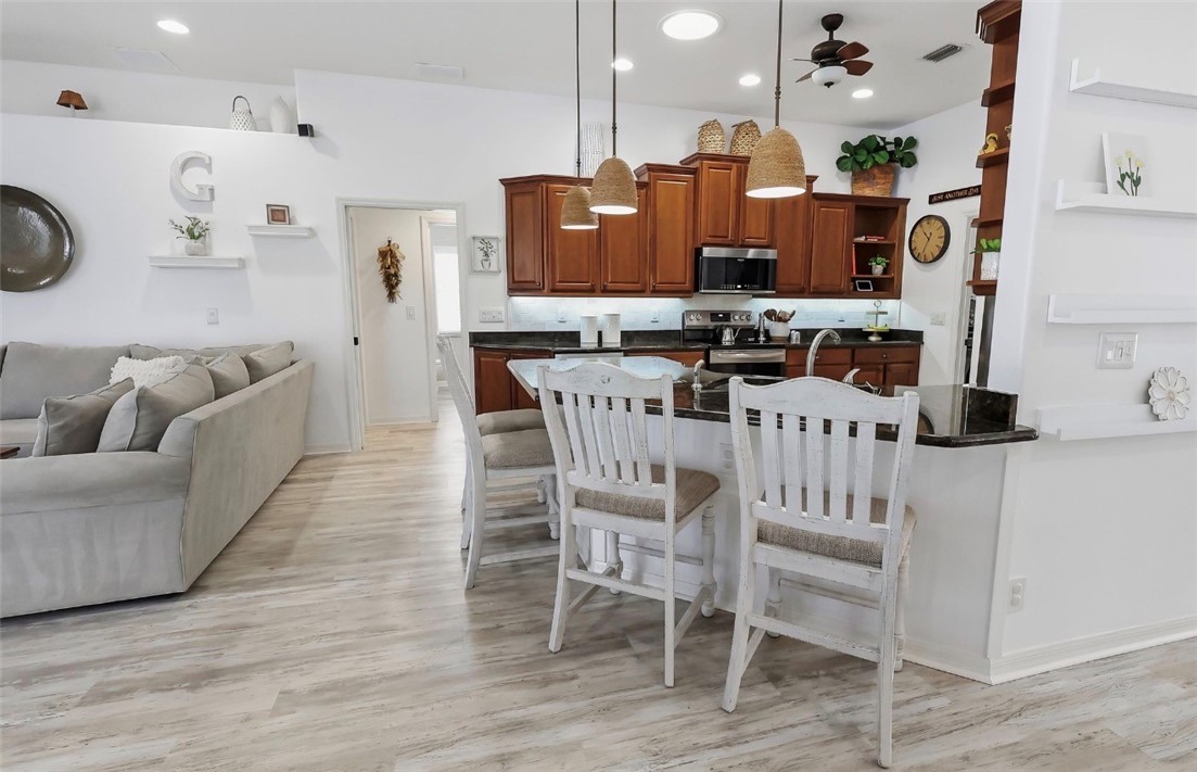 1771 Mistletoe Street Sebastian, FL 32958 - Photo 8 of 36 a kitchen with stainless steel appliances kitchen island granite countertop a table chairs and a refrigerator