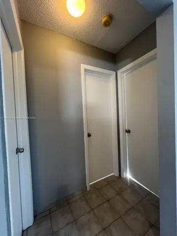 an empty room with windows and fireplace