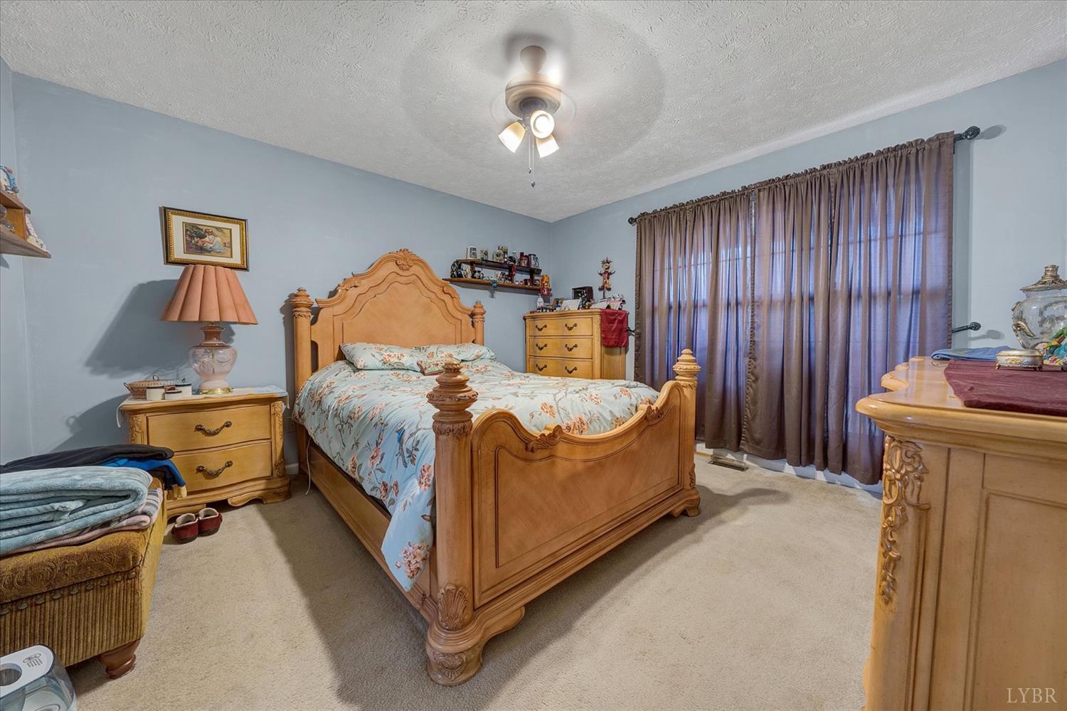 1408 Woodridge Road Blue Ridge, VA 24064 - Photo 16 of 39 a bed room with a bed and a chandelier