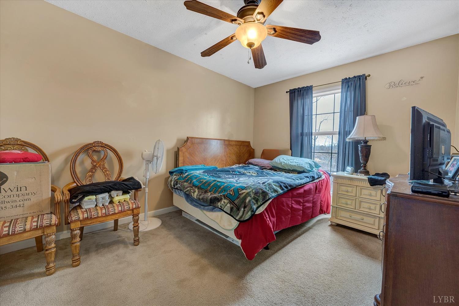 1408 Woodridge Road Blue Ridge, VA 24064 - Photo 20 of 39 a bedroom with a bed a dresser and flat screen tv