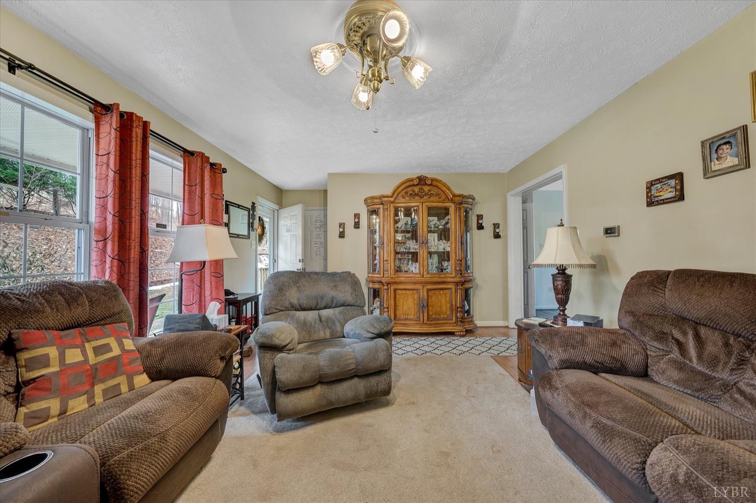 1408 Woodridge Road Blue Ridge, VA 24064 - Photo 6 of 39 a living room with furniture and a chandelier
