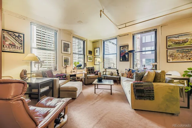 a living room with furniture ceiling fan and a window