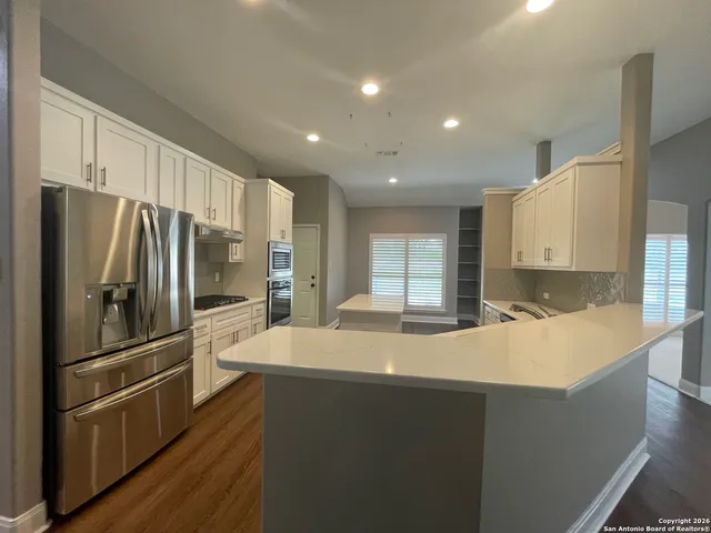 a kitchen with stainless steel appliances a refrigerator and a stove top oven