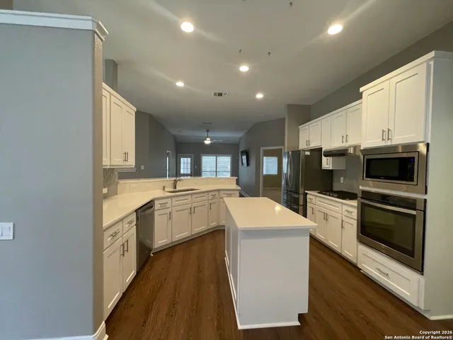 a kitchen with granite countertop a sink and stainless steel appliances