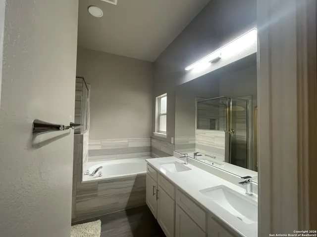 a bathroom with a granite countertop sink mirror and bathtub