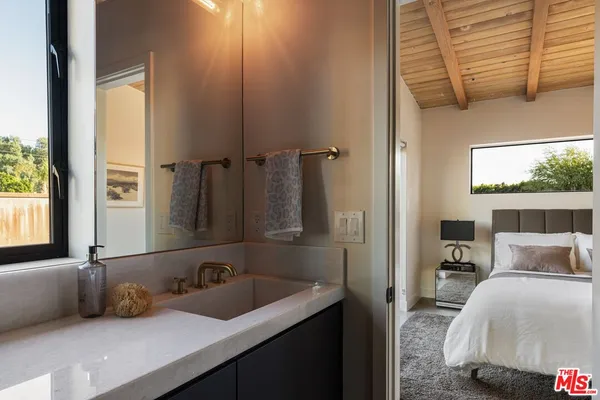 a spacious bedroom with a bed and wooden floor