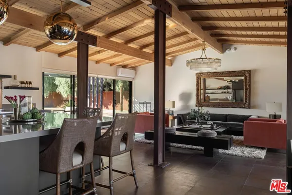 a kitchen with stainless steel appliances granite countertop a stove and a view of living room
