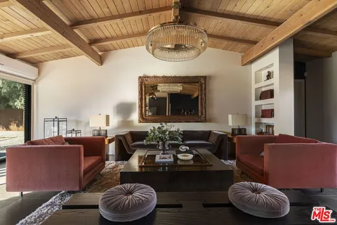 a view of a dining room with furniture a kitchen and chandelier