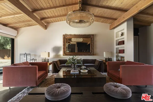 a view of a dining room with furniture a kitchen and chandelier