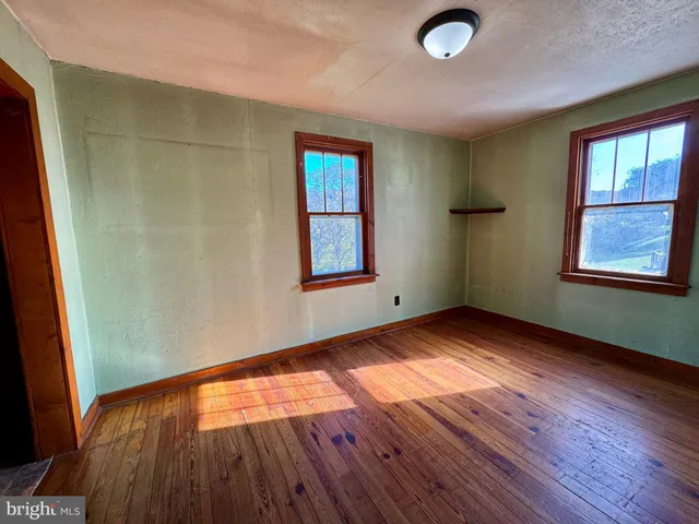 a view of a room with wooden floor and furniture