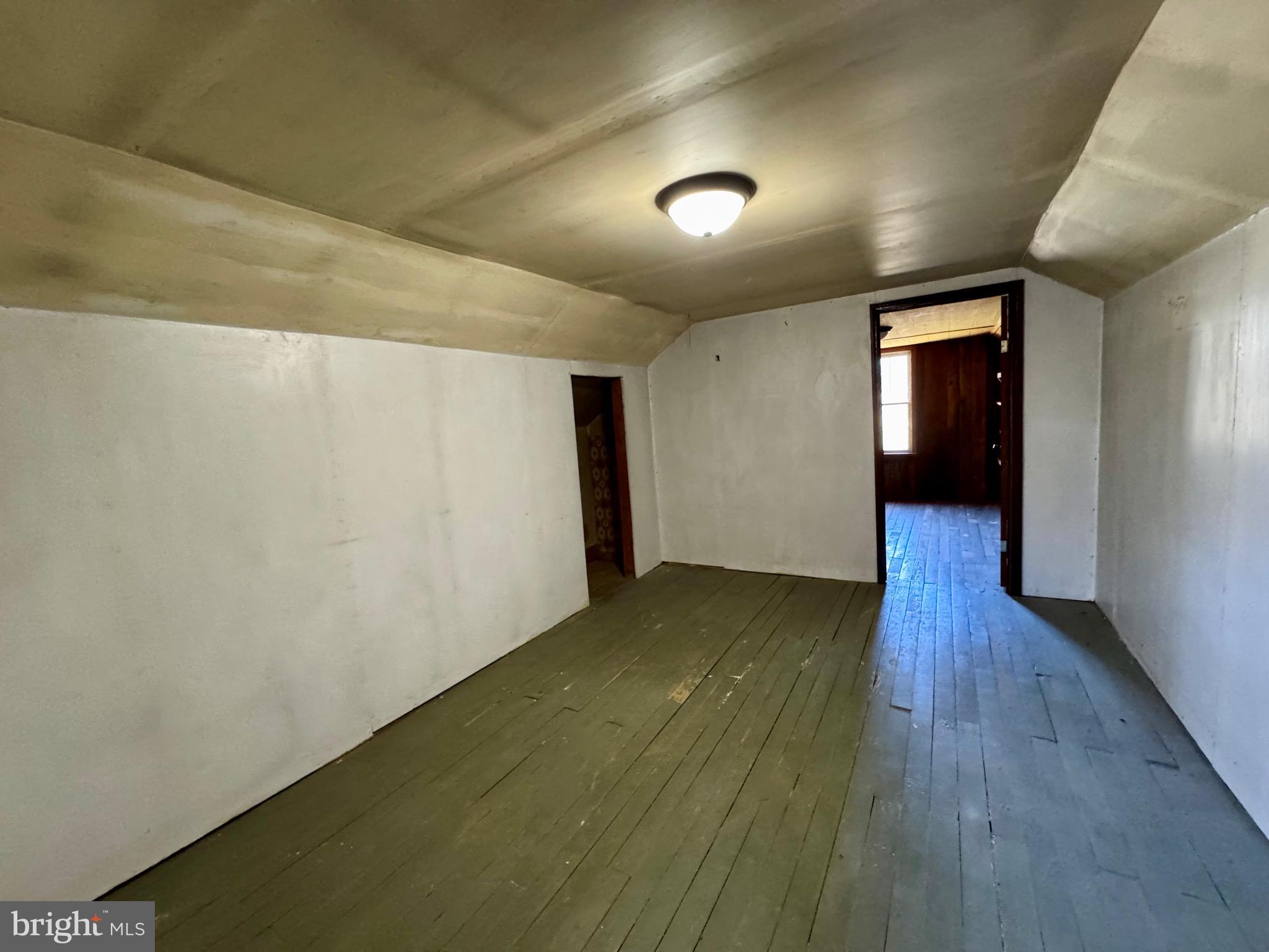 830 Harrison Avenue Berkeley Springs, WV 25411 - Photo 27 of 41 an empty room with wooden floor and windows