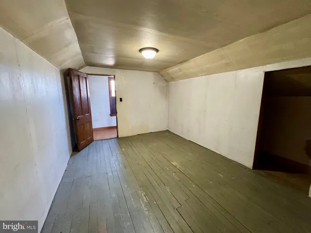 a view of a room with wooden floor and a window