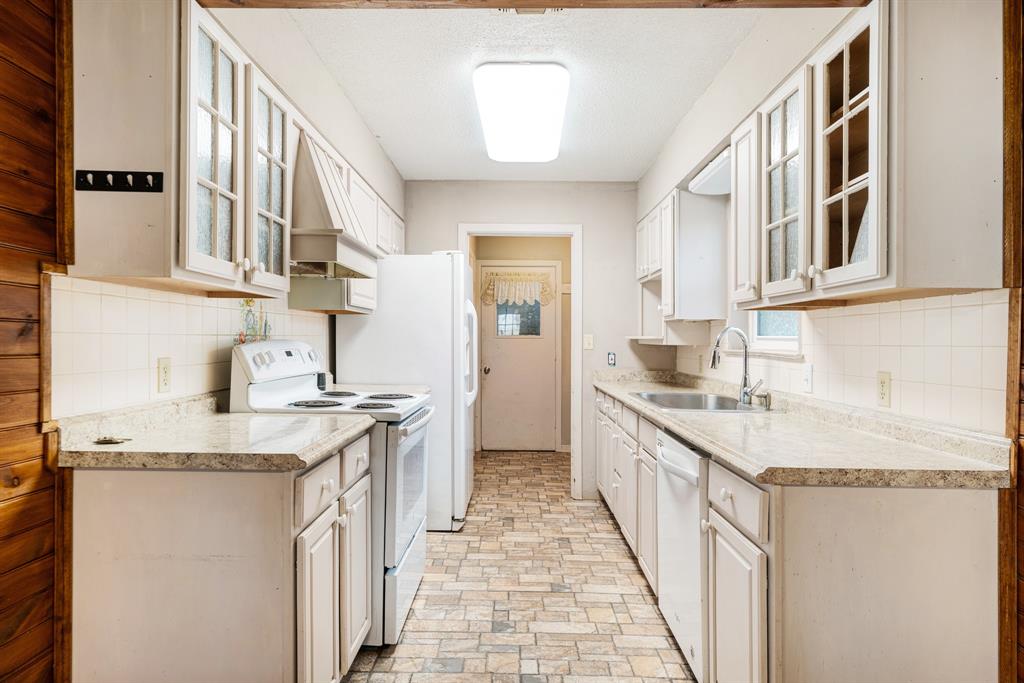 970 Mansfield Road Reno, TX 75462 - Photo 8 of 20 a kitchen with granite countertop a sink stove and cabinets
