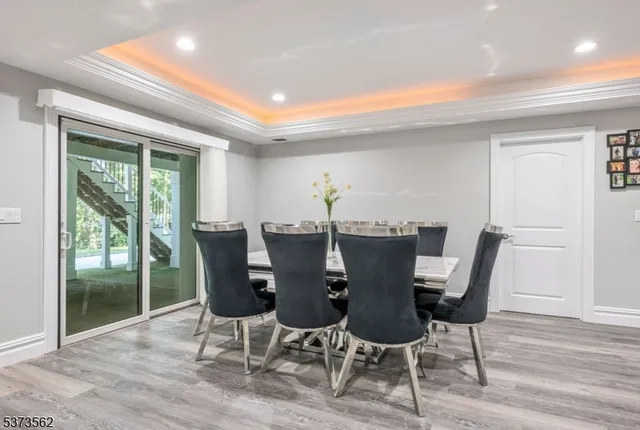 a kitchen with stainless steel appliances granite countertop a refrigerator a stove a sink dishwasher and white cabinets with wooden floor