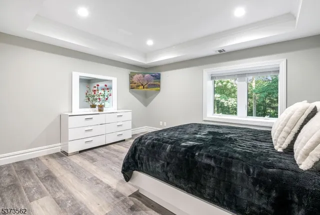 a bathroom with a toilet a sink a mirror and a window