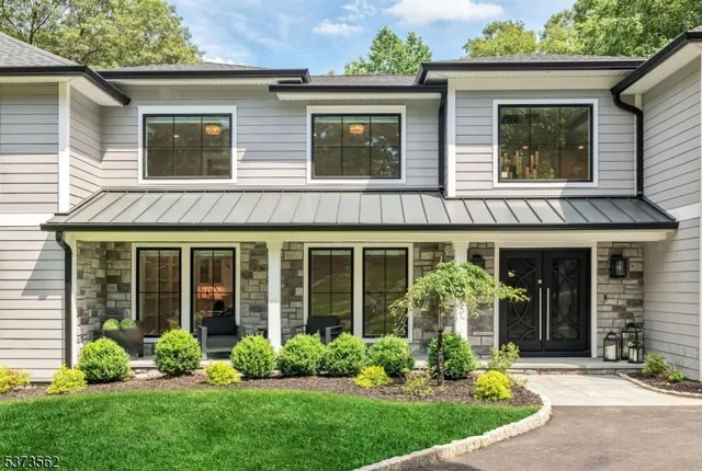 front view of a brick house with a yard and a large window