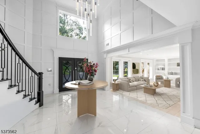 a living room with furniture a fireplace and a chandelier