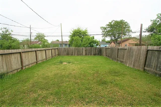 a view of a backyard with a cabin and wooden fence