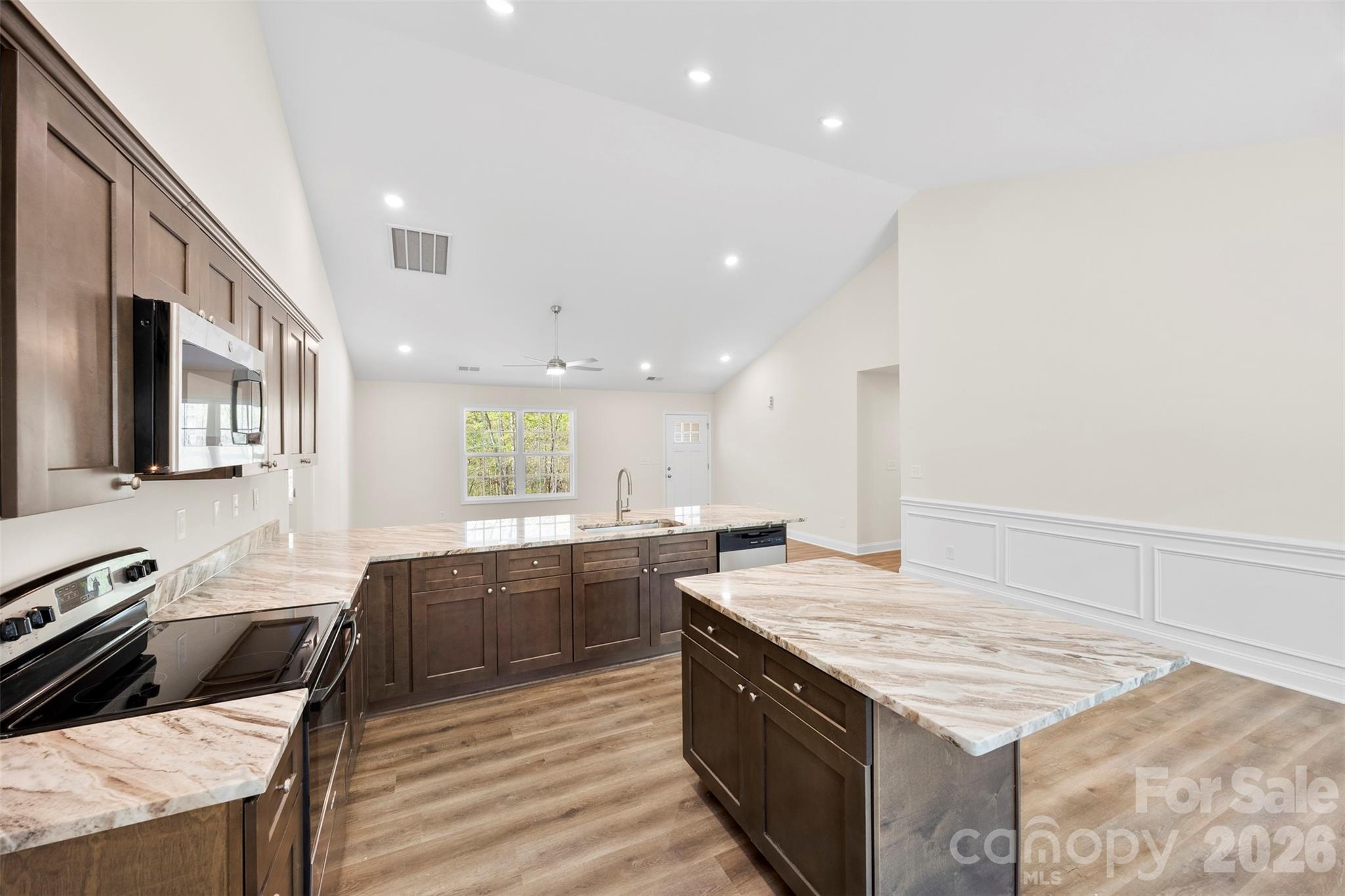 872 Roxboro Drive Mount Gilead, NC 27306 - Photo 11 of 41 a large kitchen with stainless steel appliances kitchen island granite countertop a sink and cabinets
