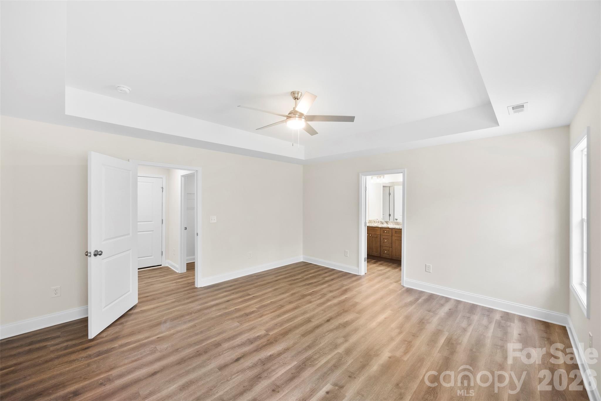 872 Roxboro Drive Mount Gilead, NC 27306 - Photo 15 of 41 an empty room with wooden floor and ceiling fan