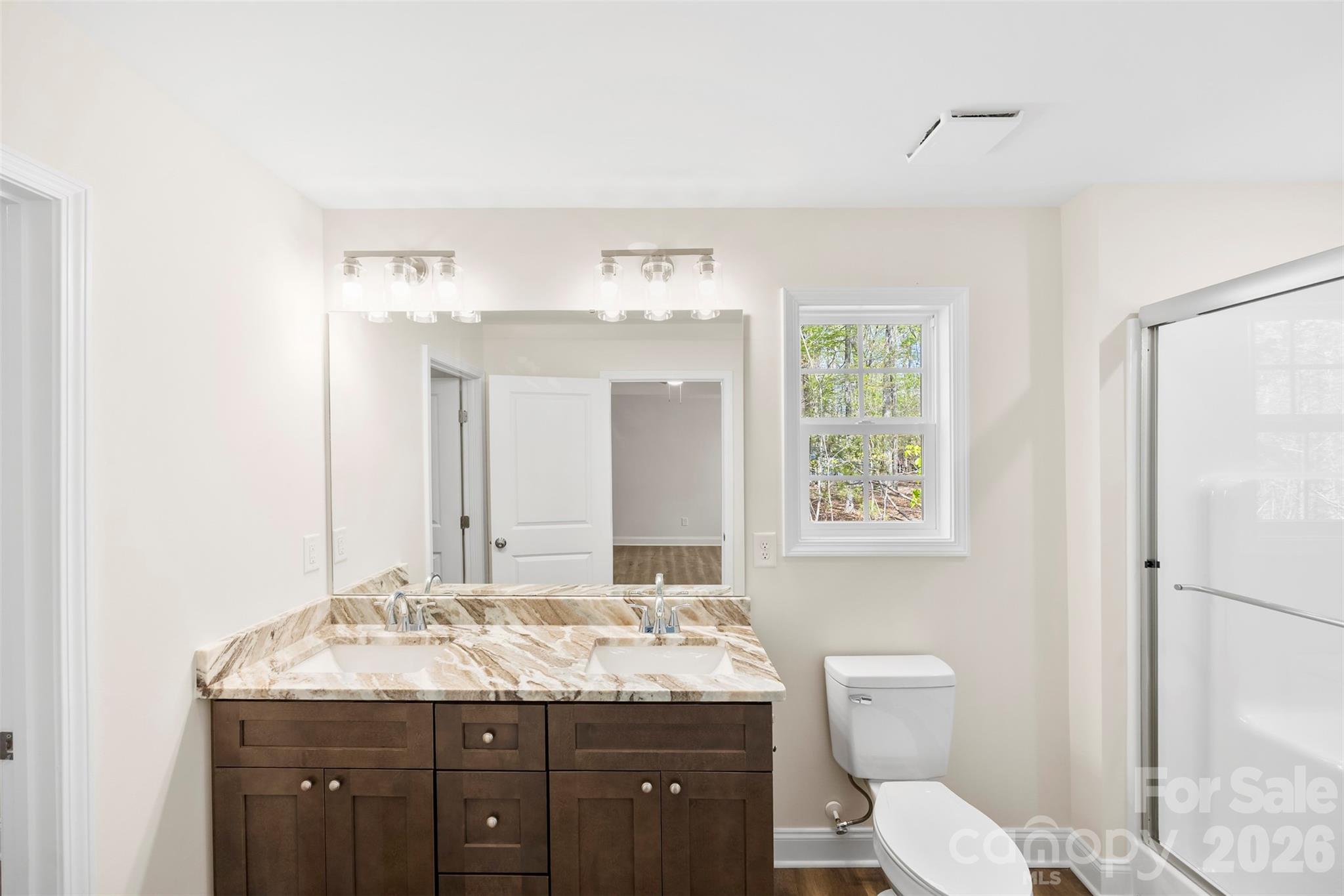 872 Roxboro Drive Mount Gilead, NC 27306 - Photo 17 of 41 a bathroom with a granite countertop toilet a sink and a mirror