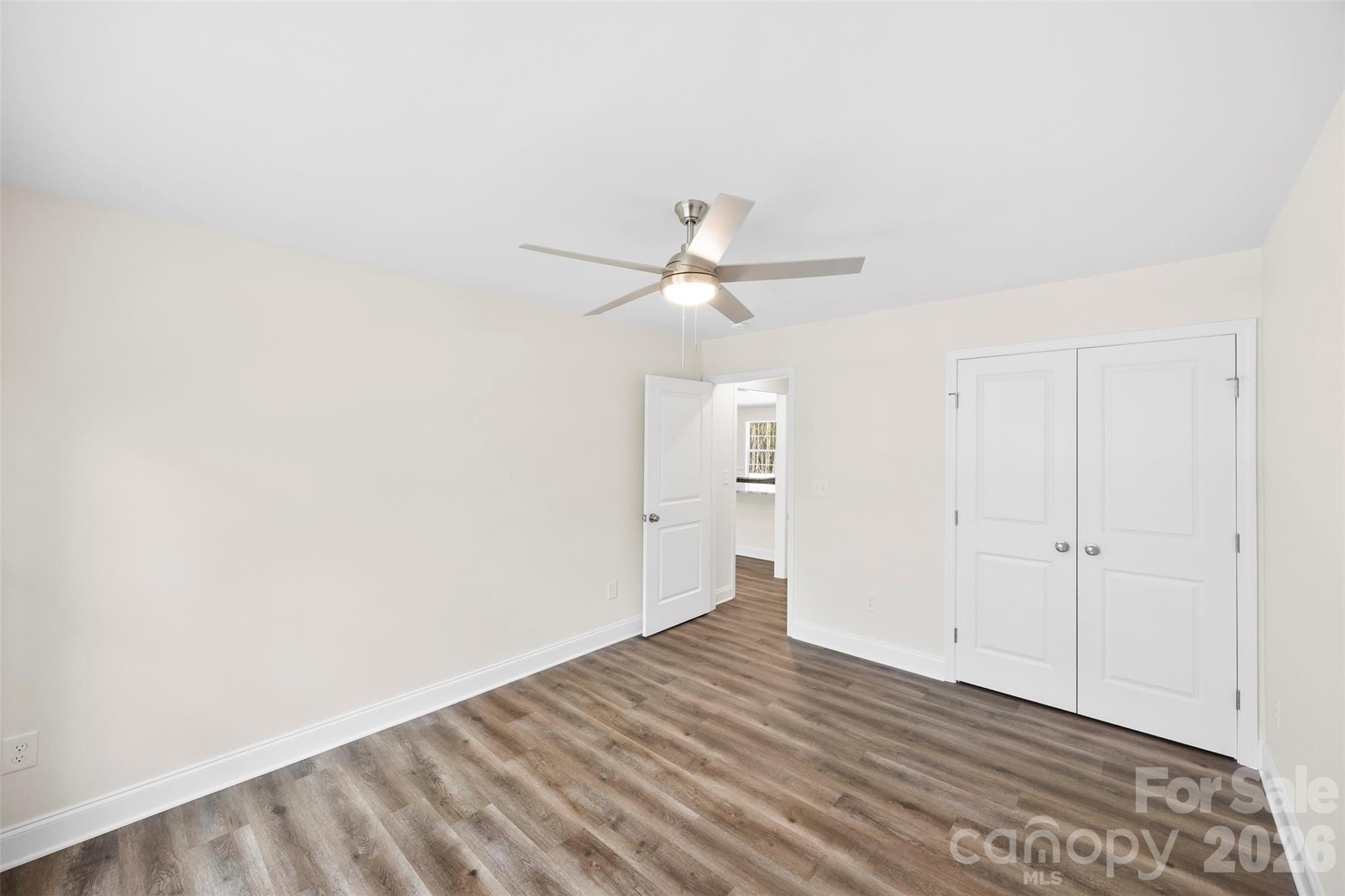 872 Roxboro Drive Mount Gilead, NC 27306 - Photo 22 of 41 a view of a room with wooden floor and a ceiling fan