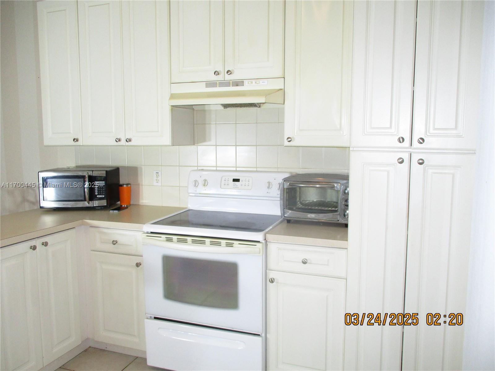 4802 Washington Street, Unit 2 Hollywood, FL 33021 - Photo 14 of 24 a kitchen with granite countertop white cabinets and white appliances