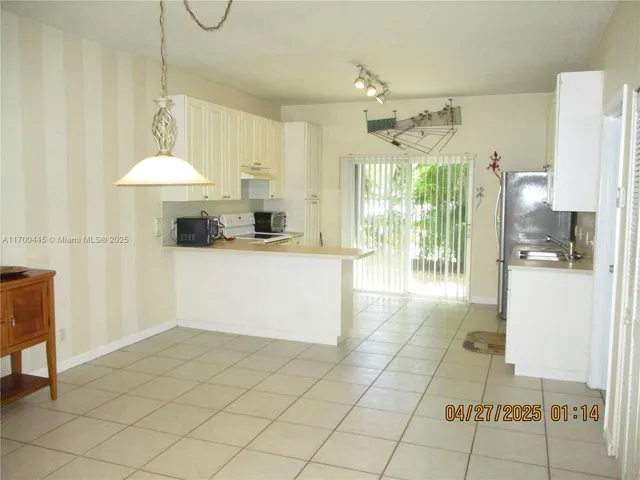 a view of a kitchen with kitchen island granite countertop lots of counter top space and cabinets