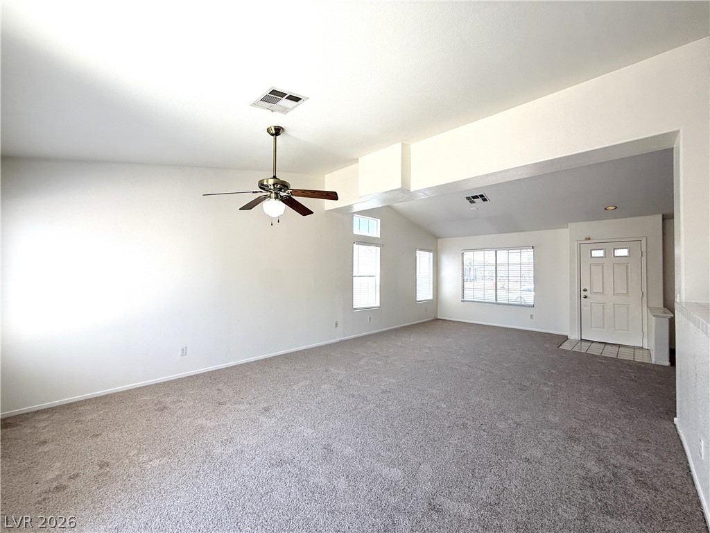 8870 Haviland Road Las Vegas, NV 89123 - Photo 3 of 22 A spacious living room features soaring vaulted ceilings and plush carpeting.