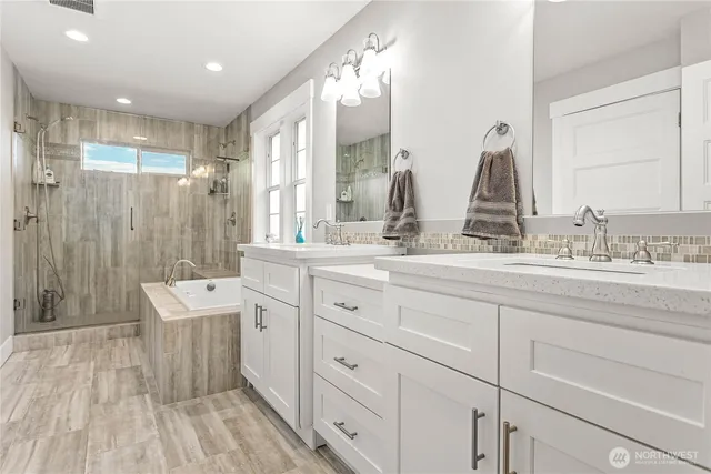 a spacious bathroom with double vanity and a mirror