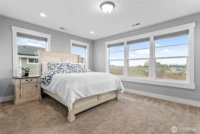 a large bed sitting in a room next to a window