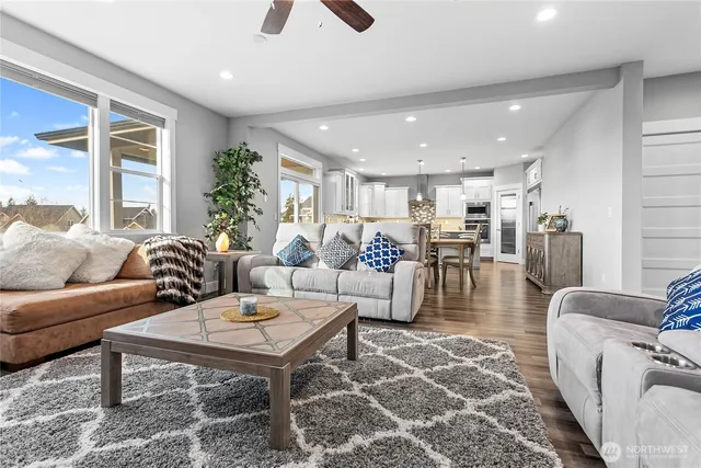 a living room with furniture a wooden floor and a large window