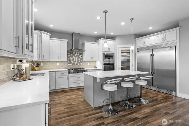 a kitchen with kitchen island a sink stainless steel appliances and cabinets