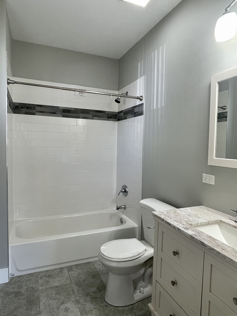 1986 Pine Street, Unit 1 Des Plaines, IL 60018 - Photo 7 of 11 a bathroom with a granite countertop toilet sink and shower